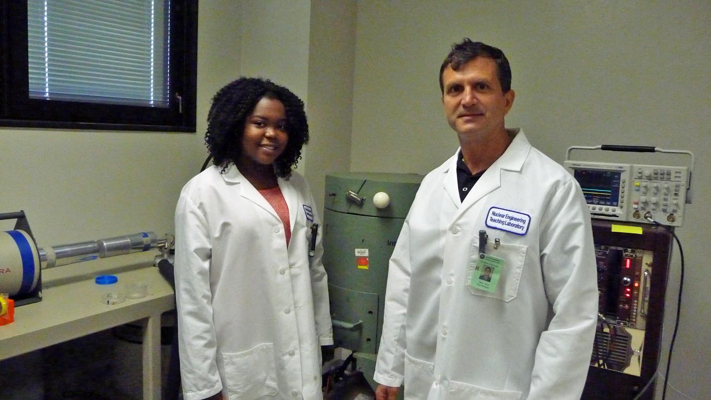 student and professor in lab coats in lab
